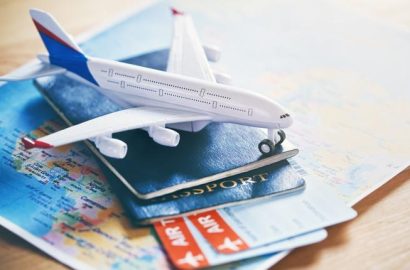 Plane model with world map, passports and tickets as airplane traveling and tickets booking concept